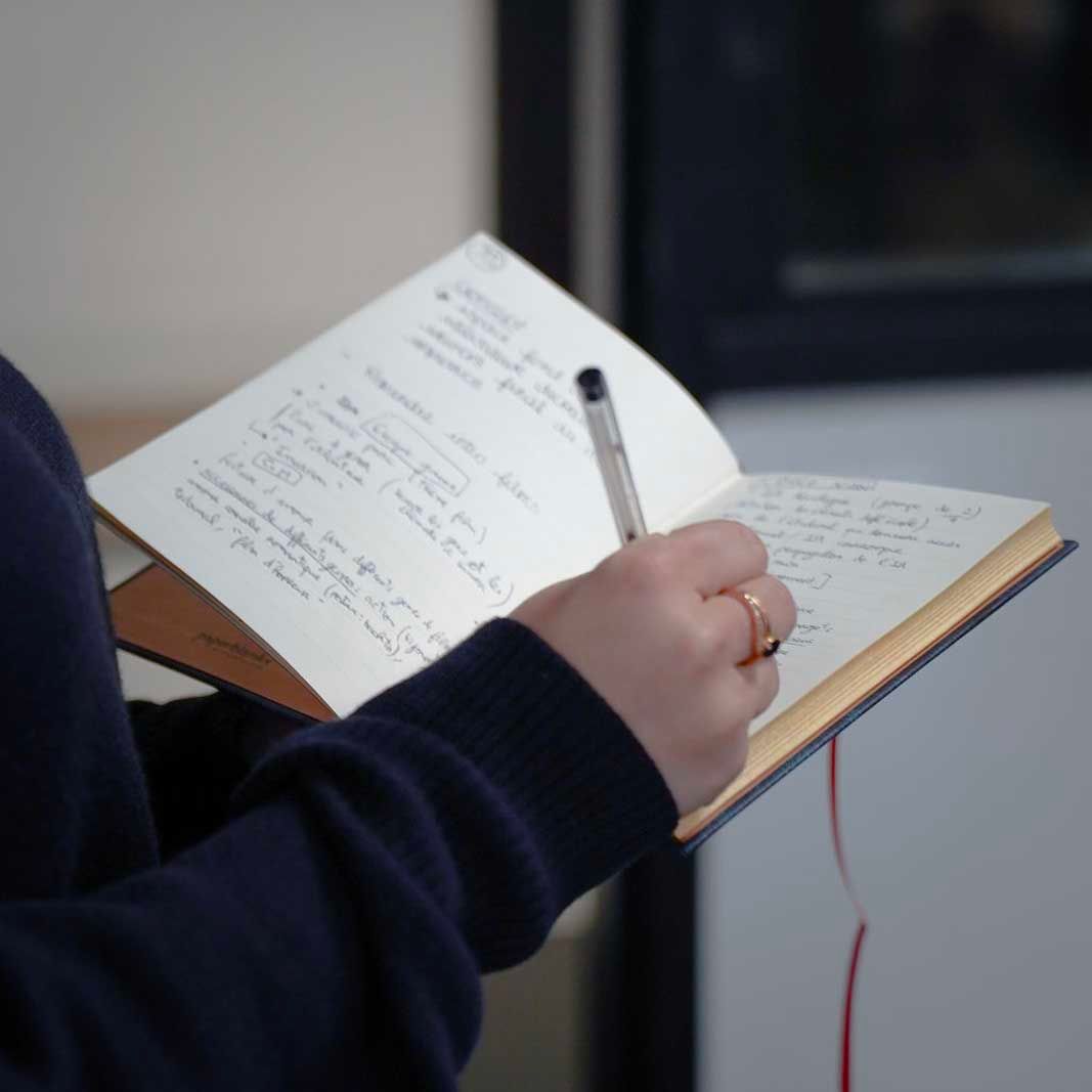 Élève en prise de notes pendant un brief client 
