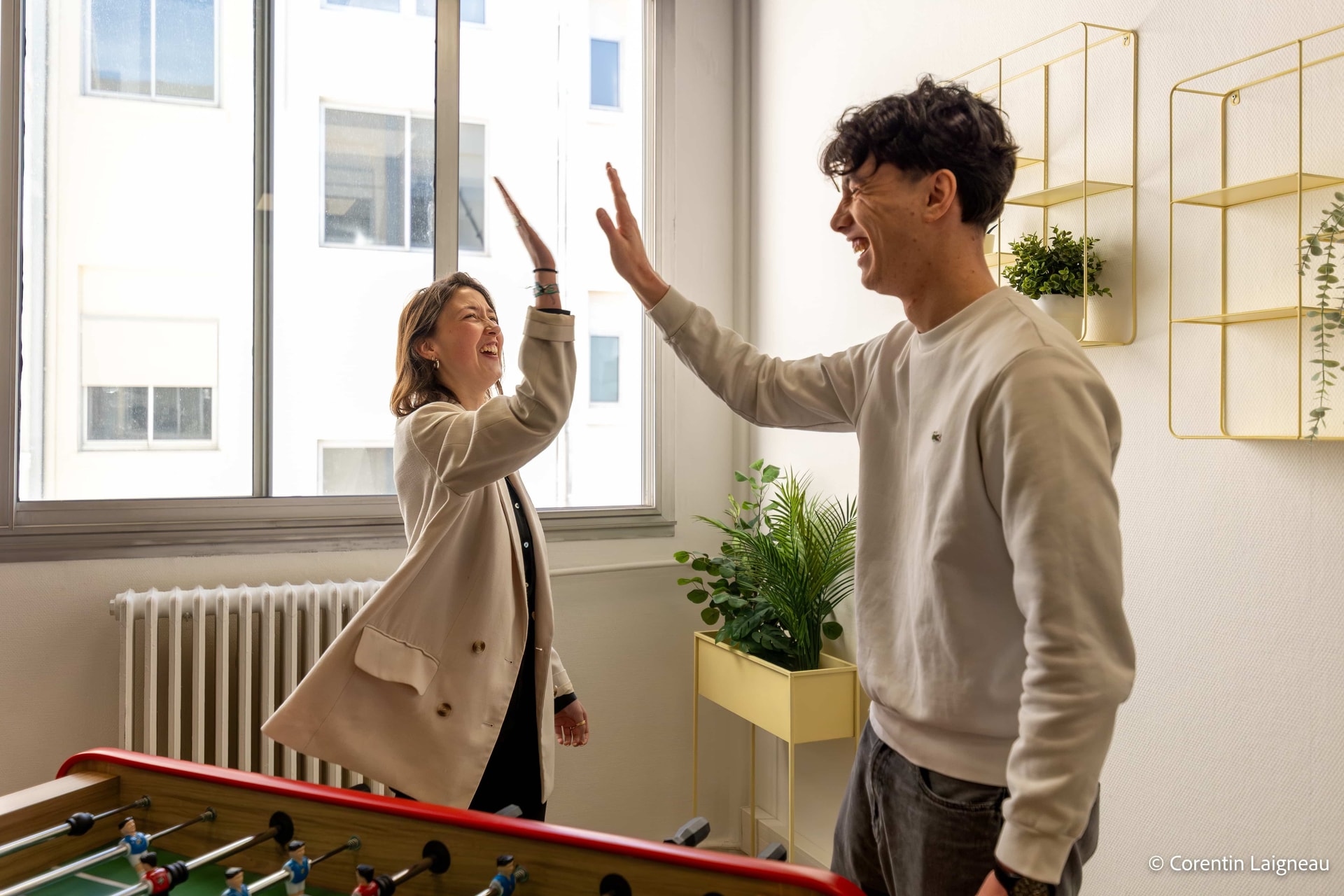 2 étudiants se tapant la main après avoir remporté la partie de baby-foot