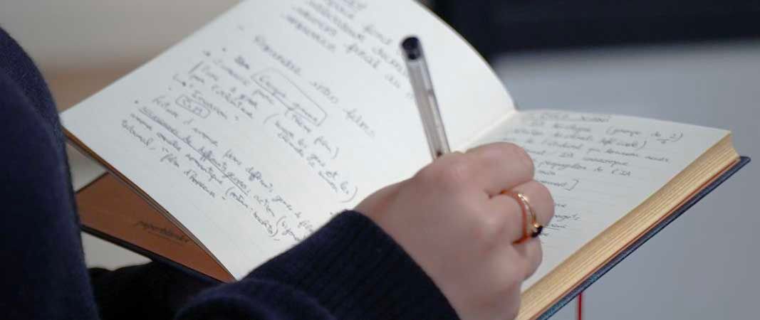 Élève en prise de notes pendant un brief client