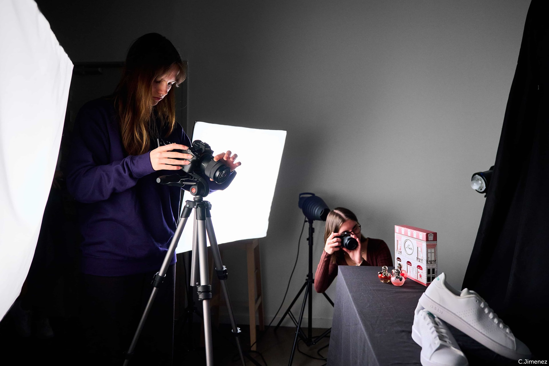 Étudiantes au studio photographiant une paire de chaussures pour une publicité
