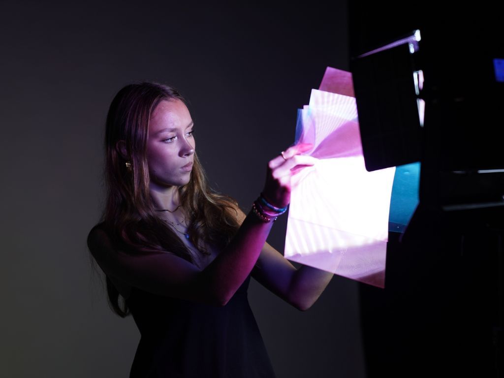 Une étudiante qui installe un calque de couleur pour faire des photos